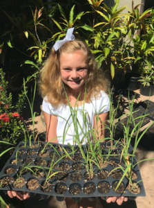 Abby Rogers posing with native plant seedlings